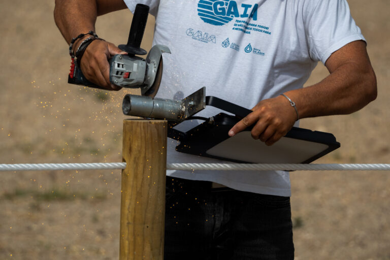 Worker using an angle grinder during final construction work at Piscina do Areinho.