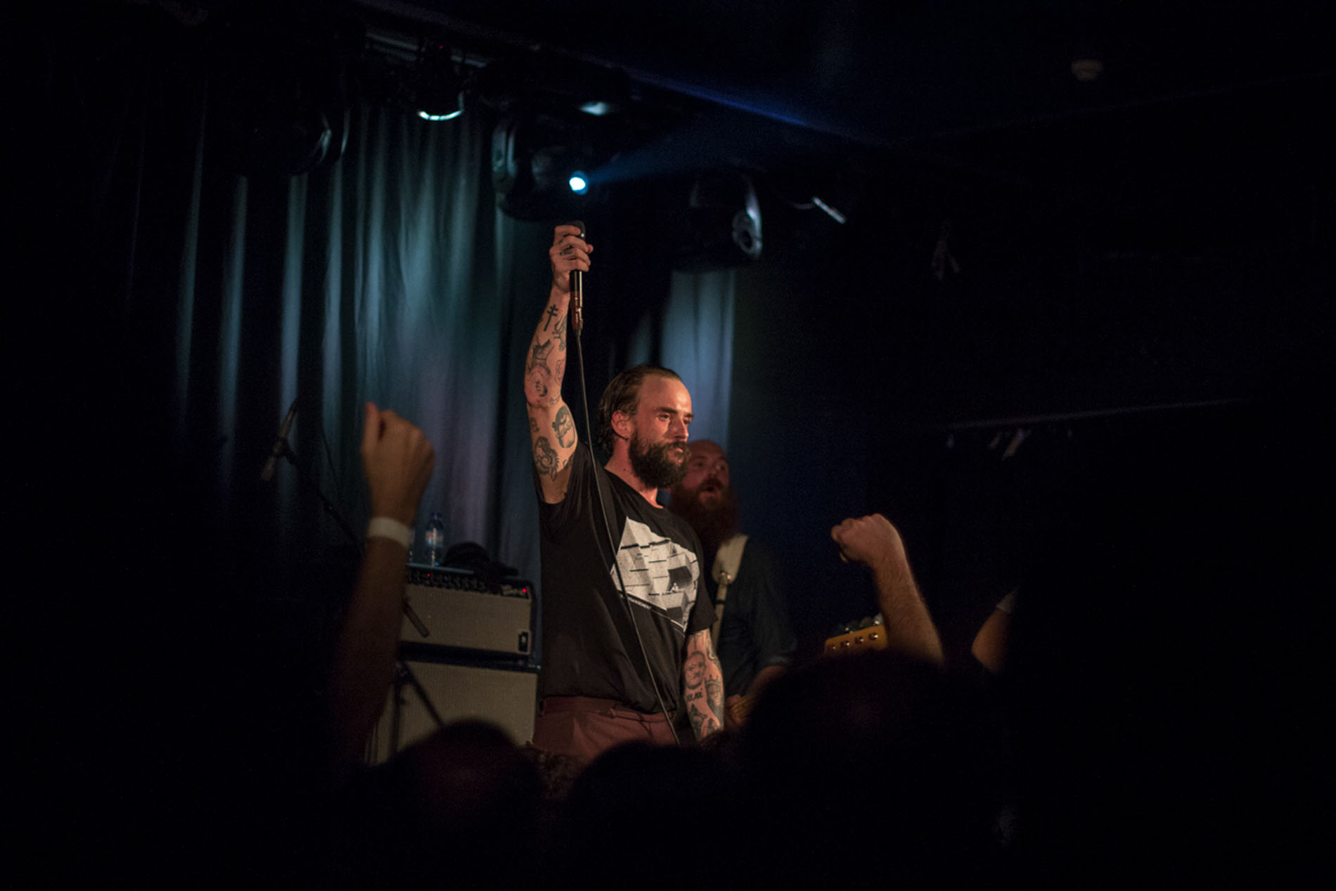 IDLES vocalist holding a microphone above the audience at Hard Club.