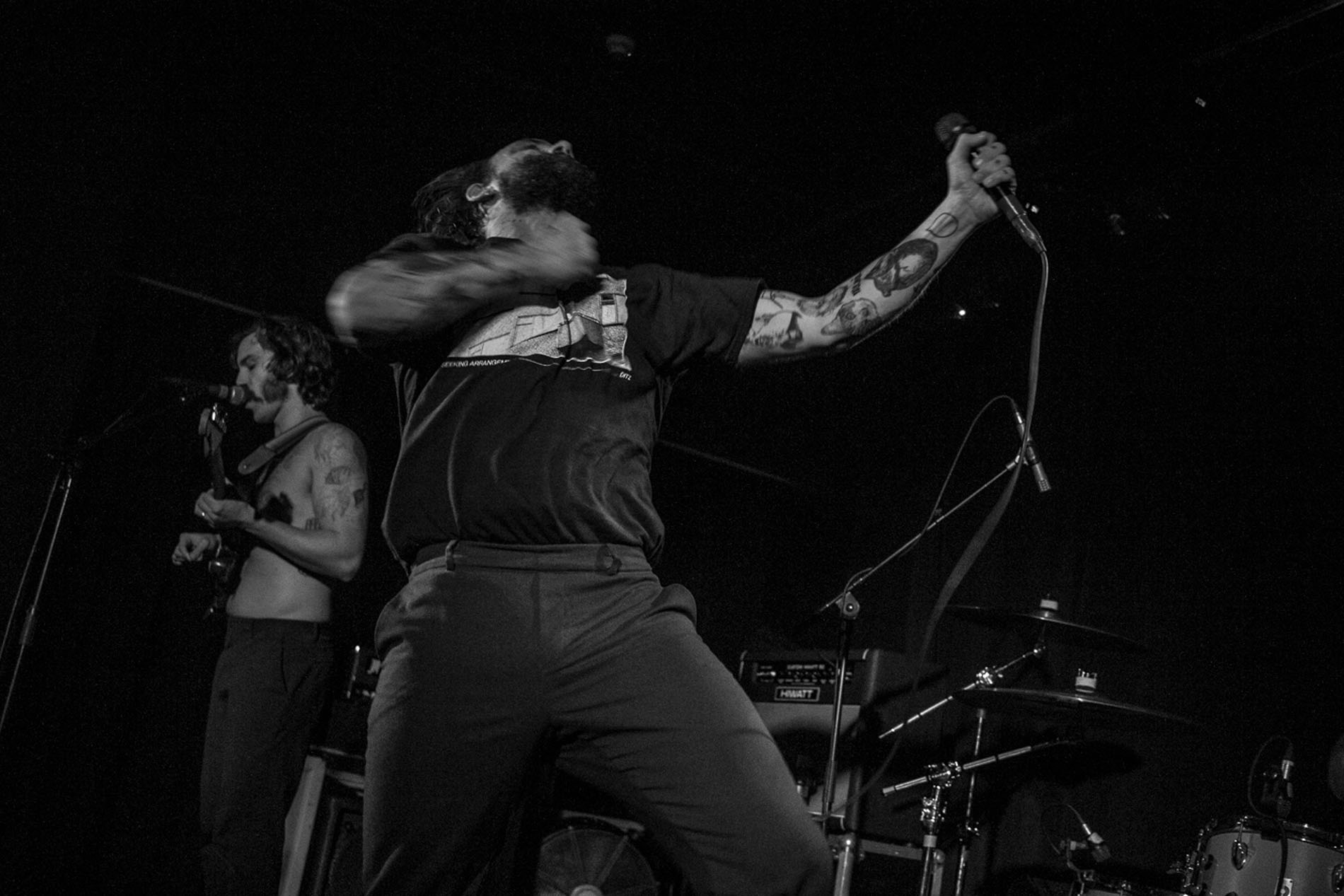 IDLES vocalist performing on stage at Hard Club, photographed in black and white.